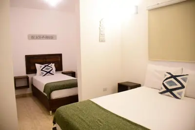 a small room with two beds and a mirror at Hostal Marina Samana in Santa Bárbara de Samaná