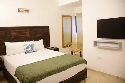 a bedroom with a bed and a flat screen tv at Hostal Marina Samana in Santa Bárbara de Samaná
