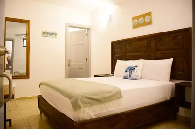 a bedroom with a large bed and a mirror at Hostal Marina Samana in Santa Bárbara de Samaná