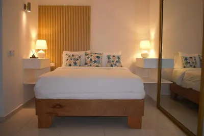 a bedroom with a large bed and a mirror at Villa Brise de Mer in Las Terrenas