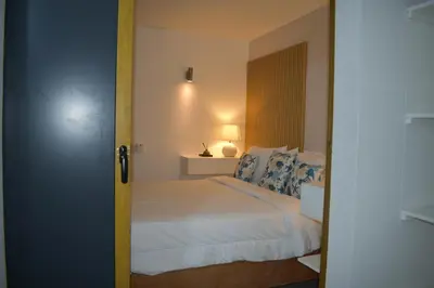 a bedroom with a white bed with blue pillows at Villa Brise de Mer in Las Terrenas