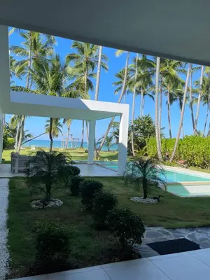 a white pavilion with palm trees and a swimming pool at Villa Brise de Mer in Las Terrenas