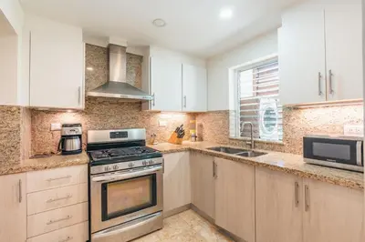 a kitchen with white cabinets and a stove top oven at Gorgeous PH at Puerto Bahia in Santa Bárbara de Samaná