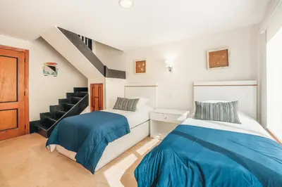 two beds in a room with a staircase at Gorgeous PH at Puerto Bahia in Santa Bárbara de Samaná