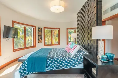 a bedroom with a bed and a tv and windows at Gorgeous PH at Puerto Bahia in Santa Bárbara de Samaná