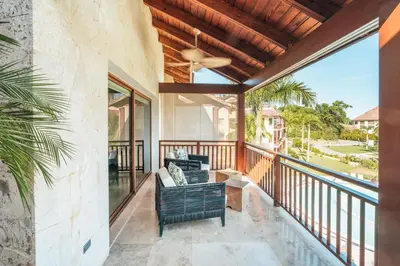 a screened porch with a couch and a ceiling fan at Gorgeous PH at Puerto Bahia in Santa Bárbara de Samaná
