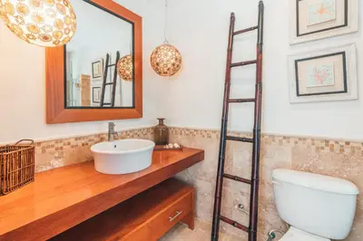 a bathroom with a toilet and a sink and a mirror at Gorgeous PH at Puerto Bahia in Santa Bárbara de Samaná