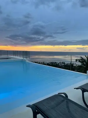 a pool with a view of the ocean at sunset at Villa Ocean Blue in Las Terrenas