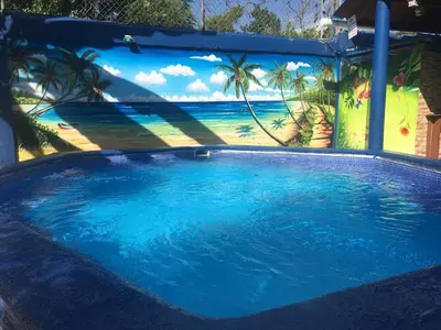 a large swimming pool with a mural of the ocean at Sana El Jardin Secreto in Santiago de los Caballeros