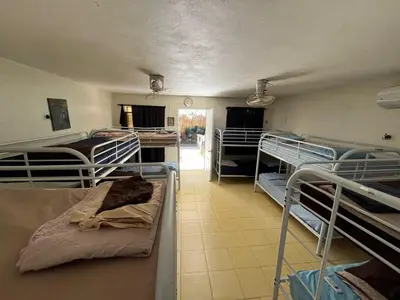 a room with several bunk beds and a hallway at Sana El Jardin Secreto in Santiago de los Caballeros