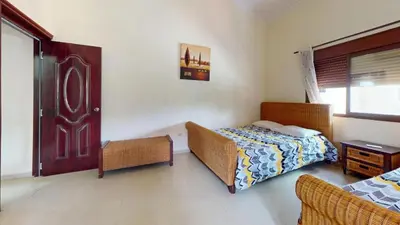 a bedroom with a bed and a table and a door at Green Paradise in Juan Dolio