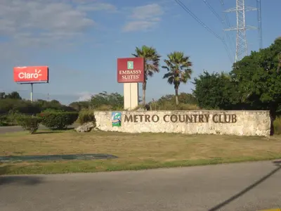 a sign for a metro country club next to a street at Green Paradise in Juan Dolio