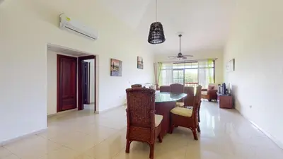 a dining room and living room with a table and chairs at Green Paradise in Juan Dolio