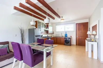a living room with a table and purple chairs at 