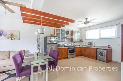 a kitchen and living room with a table and purple chairs at 