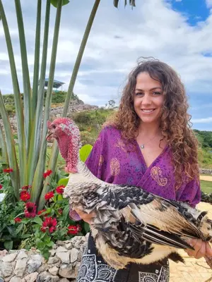 a woman holding a turkey in a garden at Finca Jasmat in Cabrera