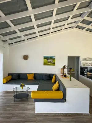 a living room with a large bed and yellow pillows at Finca Jasmat in Cabrera