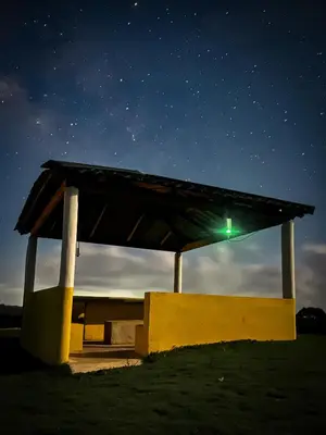 a bench with a green light under a night sky at Finca Jasmat in Cabrera