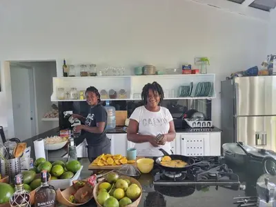 two women standing in a kitchen preparing food at Finca Jasmat in Cabrera