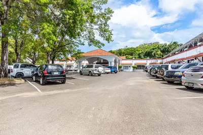 a parking lot in front of a building with cars parked at Monte Vista Apartments in Sosúa