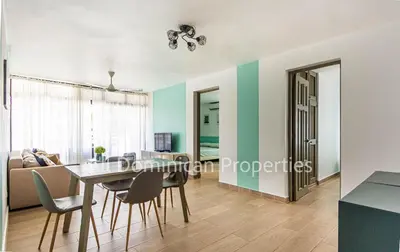 a dining room and living room with a table and chairs at Monte Vista Apartments in Sosúa