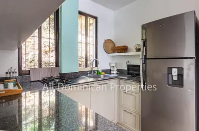 a kitchen with a stainless steel refrigerator and windows at Monte Vista Apartments in Sosúa