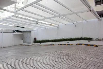an empty room with a white wall with plants at Modern and centric Apartment with pool and gym at Downtown in Santo Domingo