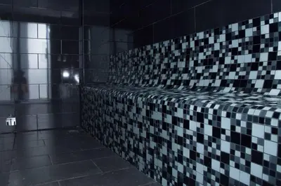 a bathroom with a black and white tiled wall at Modern and centric Apartment with pool and gym at Downtown in Santo Domingo