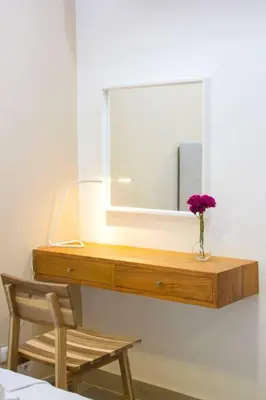 a dresser with a mirror and a vase of flowers on it at Modern and centric Apartment with pool and gym at Downtown in Santo Domingo