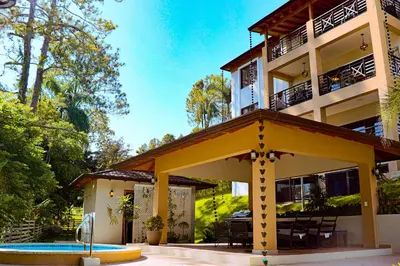 a building with a pool in front of it at Vista del Campo Country Club & Villas in Jarabacoa