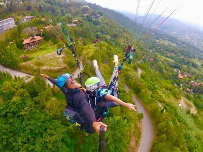 two people are hanging from a parachute at Vista del Campo Country Club & Villas in Jarabacoa
