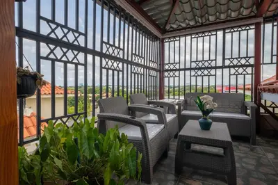 a room with chairs and tables and windows at Loft con terraza en Santo Domingo in La Estrella