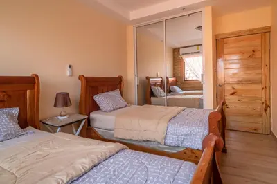 a bedroom with two beds and a mirror at Loft con terraza en Santo Domingo in La Estrella