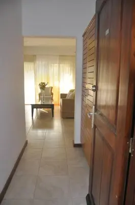 a hallway with a wooden door and a living room at Apartamento con vista a la piscina in Las Terrenas
