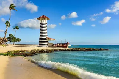 a lighthouse on a beach with the ocean at El Rinconcito Caribeño in La Laguna
