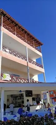 a group of people sitting in chairs in front of a building at El Rinconcito Caribeño in La Laguna