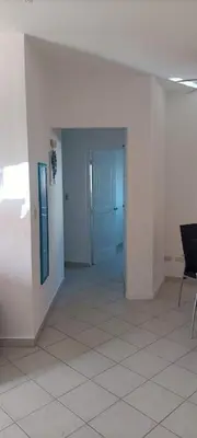 a hallway with white walls and a room with a chair at El Rinconcito Caribeño in La Laguna