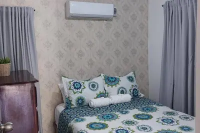 a bedroom with a bed with blue and white pillows at Beautiful sea front apartment in Paraíso