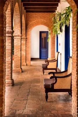 a row of benches sitting in an alley with a blue door at Casas del XVI in Santo Domingo
