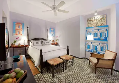 a bedroom with a bed and a table and chairs at Casas del XVI in Santo Domingo