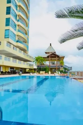 a large swimming pool next to a tall building at Beach Front Penthouse in Exclusive Tower in Santo Domingo