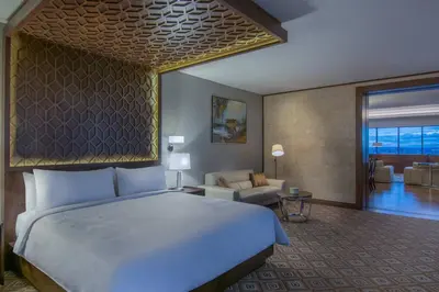 a bedroom with a large bed and a living room at JW Marriott Hotel Santo Domingo in Santo Domingo