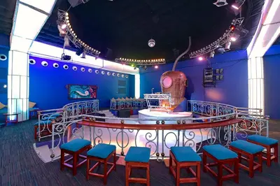 a room with a bar with blue walls and stools at Iberostar Selection Hacienda Dominicus - All Inclusive in Bayahibe