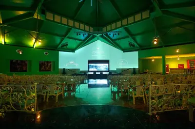 a room filled with tables and chairs and a screen at Iberostar Selection Hacienda Dominicus - All Inclusive in Bayahibe