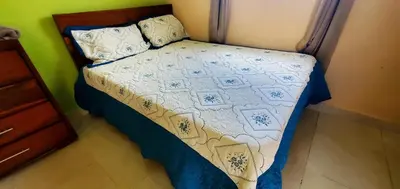 a small bed in a bedroom with a bedspread and pillows at HOTEL RANCHO EL NOVATO in Concepción de La Vega