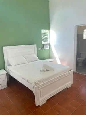 a bed in a room with a white bed frame at Palms Lounge Cabarete in Cabarete