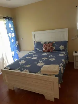 a bedroom with a bed with a blue comforter at Palms Lounge Cabarete in Cabarete