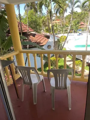a balcony with two chairs and a view of a pool at Palms Lounge Cabarete in Cabarete