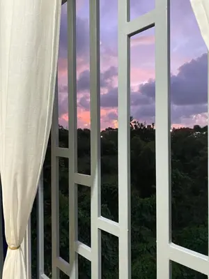 a window with a view of a sunset at Tiny Apartment By Merengue House ,8 minutos airport in Santo Domingo