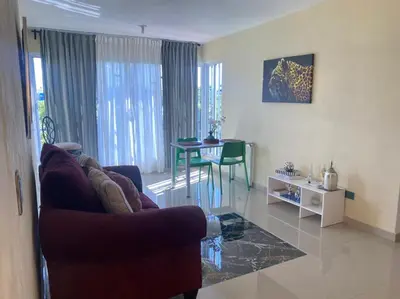 a living room with a couch and a table at Tiny Apartment By Merengue House ,8 minutos airport in Santo Domingo